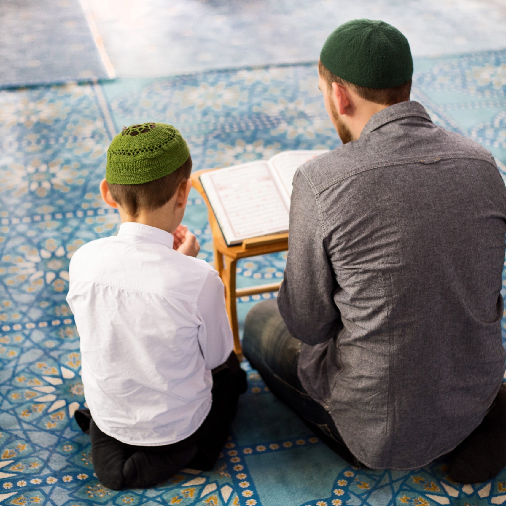 Father and sons pray in the mosque